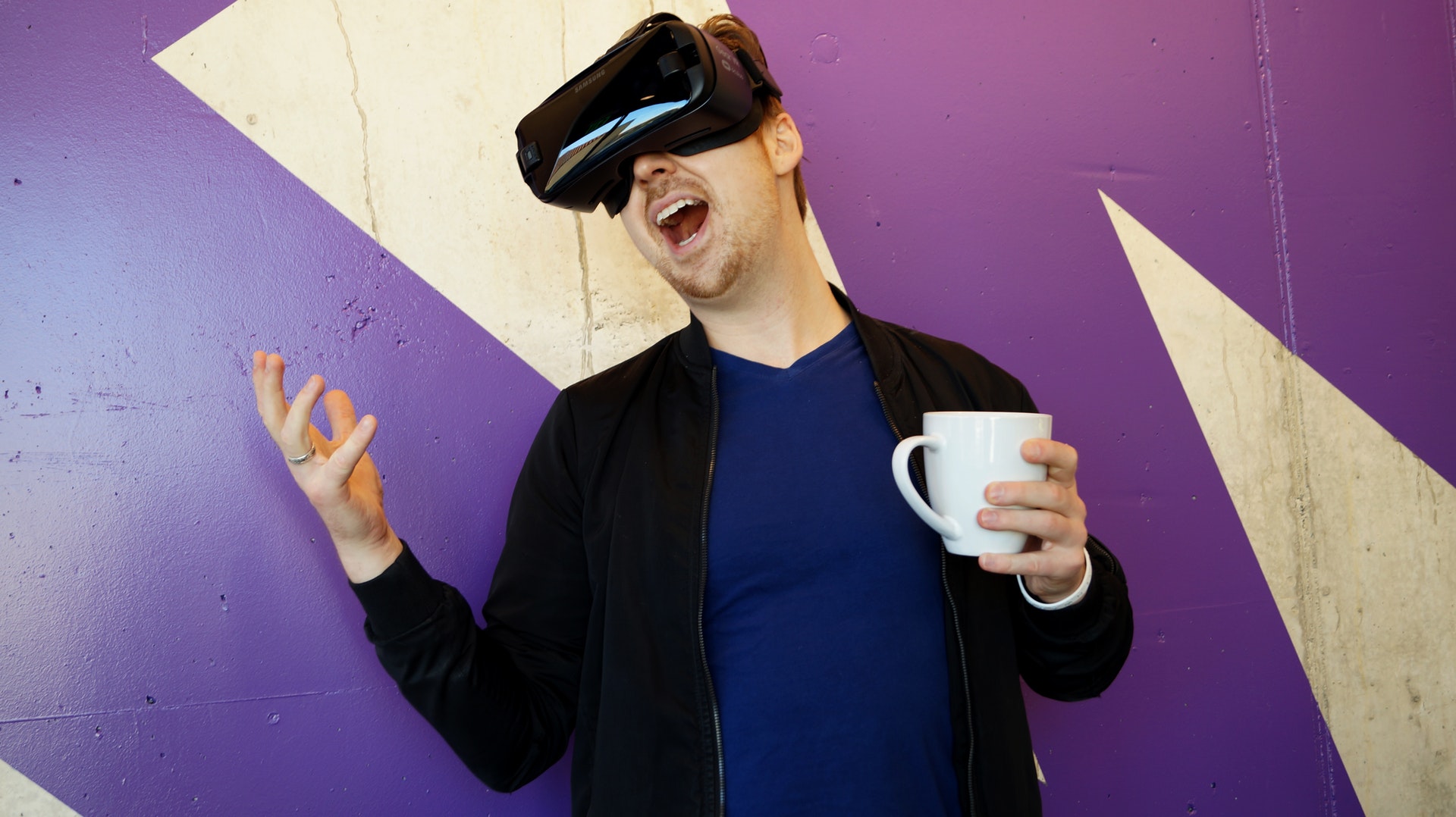 Mann mit VR-Brille und Kaffeetasse